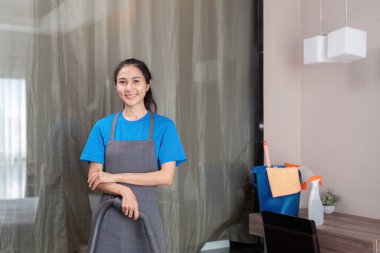 Temizlik ürünleri, ve evde bakterileri temizlemek için yatak odasında Asyalı kadın temizlik sepetleri. Oda temizleyici ya da konteynırlı hizmetçi..