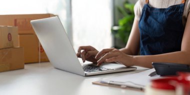 İnternetteki bir kadın, dizüstü bilgisayardaki müşteri adresini ve paket bilgilerini kontrol ediyor. Çevrimiçi alışveriş kavramı.