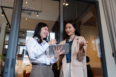 Dijital tablet teknolojisi kullanarak çalışan iş kadını şirket toplantılarında finansal pazar verilerini tartışıyor..