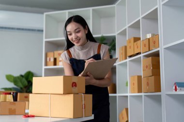 Girişimci kadın, paket kutusunu hazırla ve online siparişi kontrol et. Ticari çek teslimatı için. Online pazarlama, paketleme kutusu, KOBİ satıcısı. başlangıç iş konsepti.