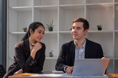 Ortak iş adamı ve iş kadınlarından oluşan bir ekip masada dizüstü bilgisayar ve tablet üzerinde proje tartışıyor. Profesyonel iş adamlarının iki meslektaşı birlikte çalışıyor..