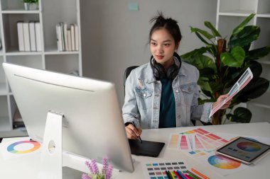 UX tasarımcısı. Yaratıcı uygulamalar üzerinde çalış. Elinde palet olan bir adam. Tasarımcı birincil renkleri monitörlere uygular. Eğitim başvurusunun geliştirilmesi. Tasarımcı serbest çalışır..