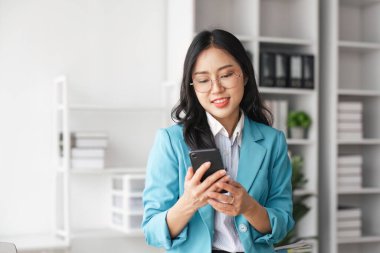 Bir şirkette cep telefonu kullanan bir iş kadını internette bir konuşma yazıyor..
