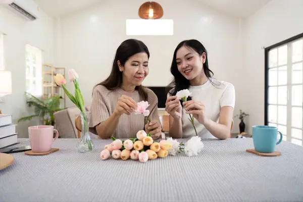 Ibu Dan Anak Yang Bahagia Mengatur Bunga Dalam Vas Meja Stok Gambar Bebas Royalti