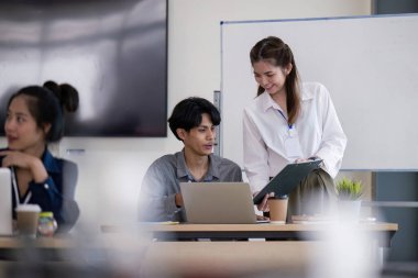 Verileri analiz eden ve modern ofis ortamında stratejiyi tartışan bir iş ekibi, dizüstü bilgisayarlar ve bir beyaz tahta sunuyor..