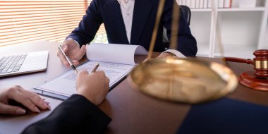 Profesyonel bir avukat, bir ofis ortamında bir müşteriyle iş sözleşmesi imzalıyor. Yasal anlaşma ve iş ortaklığını simgeliyor..