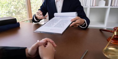 A professional lawyer signing a business contract with a client in a modern office setting, symbolizing legal services, business deals, and corporate law. clipart