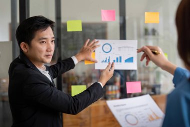 Profesyonel iş ekibi verileri analiz ediyor ve modern ofis ortamında grafikler ve grafiklerle stratejiyi tartışıyor..