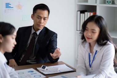 Modern ofis ortamında yapılan bir toplantıda profesyonel iş ekibi analiz ve planlama ile meşgul oldu..