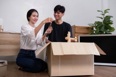 A joyful couple unpacking boxes in their new home, symbolizing a fresh start and new beginnings in a modern living space. clipart