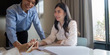 Modern ofis ortamında verileri birlikte analiz eden, işbirliği ve stratejik planlamayı teşvik eden bir iş ekibi.