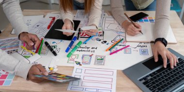 UX geliştiricileri ve UI tasarımcılarından oluşan bir ekip, kullanıcı arayüzlerini geliştirmek ve uygulamak için yaratıcı araçlar ve dijital prototipler kullanarak bir beyin fırtınası oturumuna katıldı..