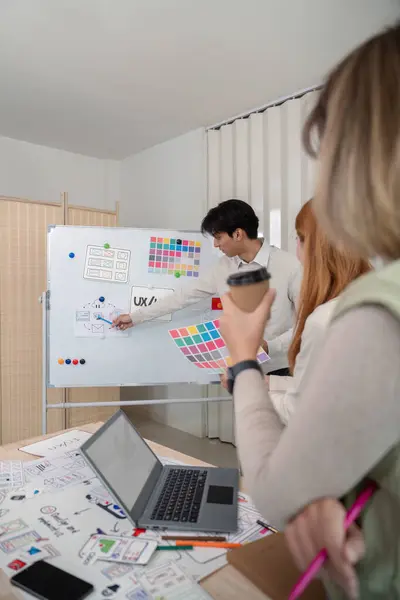 stock image A UX developer and UI designer collaborate during a brainstorming session, discussing color palettes and wireframes in a modern office setting.