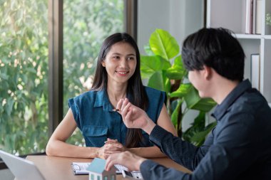 Model ev ve dizüstü bilgisayarla, parlak, modern bir ev ortamında emlak yatırımları üzerine bir tartışmaya giriştim..