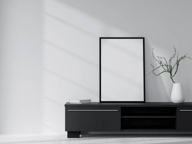 Beyaz vazo ve kitaplarla dolu siyah bir dolabın üzerinde boş bir çerçeve bulunan modern bir minimalist iç mekan..