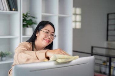 Neşeli bir hizmetçi modern bir evin içini temiz ve düzenli bir ortamla temizliyor..