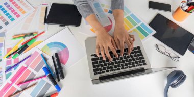 Bir dizüstü bilgisayar, renk paletleri ve çeşitli tasarım araçlarıyla bir grafik tasarımcılarının çalışma alanının genel görünümü, yaratıcılığı ve verimliliği göstermektedir..