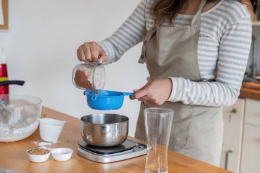 Bir ev mutfağında yemek malzemeleri hazırlayan eller, lezzetli ev yapımı hamur işleri yaratma adımlarını vurguluyor..