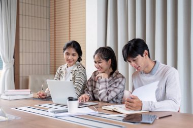 Mutlu öğrenciler kapalı bir çalışma grubunda, akademik amaçlara ulaşmak için notlarını ve fikirlerini paylaşıyorlar..