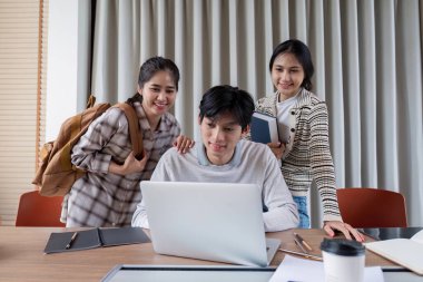 Üniversite öğrencileri kapalı alanlarda grup çalışması yapıyor, takım çalışmasını ve akademik başarıyı teşvik ediyor, eğitim materyalleriyle çevrili..