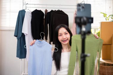 İnternette canlı kıyafet satışı, e-ticaret anlaşması ve interaktif satış teknikleri sunan genç bir kadın..