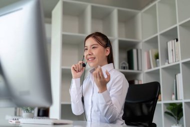 Müşterilerle iletişim kuran bir çağrı merkezi çalışanı, müşteri hizmetleri etkileşimini ve etkili problem çözmeyi vurguluyor.