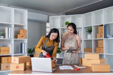 E-ticaret paketlerinin lojistiğini organize eden ve yöneten iki kadın, iyi yapılandırılmış bir ofiste verimlilik ve doğruluğu güvence altına alıyor.