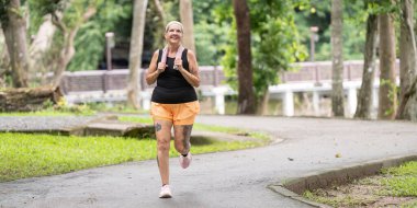Yeşil park ortamında dövmeleri olan aktif bir son sınıf öğrencisi. Sağlıklı bir yaşam tarzına ve açık hava sporlarına olan bağlılığını vurguluyor..