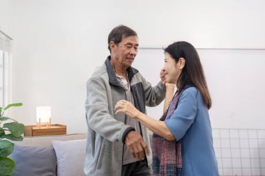 Yaşlı bir çift, birbirlerine olan sevgilerini paylaşırken gülücüklerini ve kahkahalarını paylaşarak oturma odalarında keyifli bir dans eder..