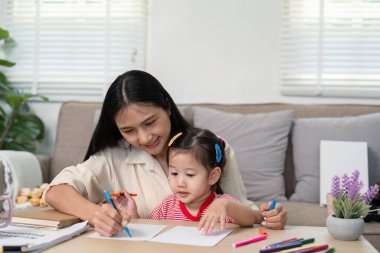 Anne ve kızı kendilerini sanatsal becerilerini geliştirmek ve güçlü bir bağ geliştirmek için evde yaratıcı bir çizim seansına sokuyorlar..