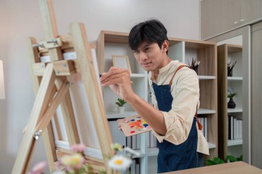 Stüdyoda resim yapmaya hevesli bir sanatçı, sakin bir ortamda tutkuyu ve zanaatı resmediyor..