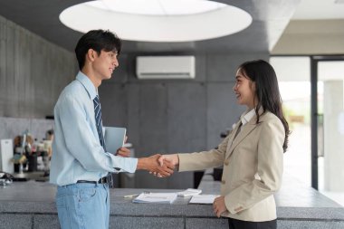 Modern bir kafe ortamında iki profesyonel arasında başarılı bir anlaşma ve ortaklığı simgeleyen bir iş tokalaşması..