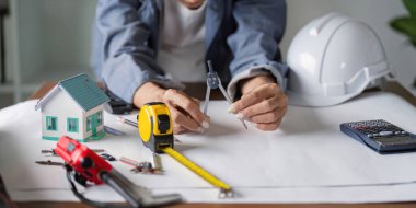 Bir mimar, inşaat projelerinin hassasiyeti ve yaratıcılığı için gerekli olan doğru yapı planı tasarımlarını yaratmak için pusula gibi modelleme araçlarından yararlanır..