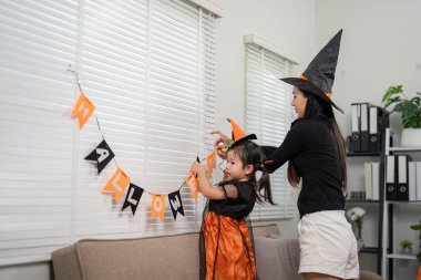 Cadılar Bayramı dekorasyonu üzerine bir çocuk ve ebeveyn arasındaki bağ, evde şenlik ruhunu ve yaratıcılığı artırıyor..