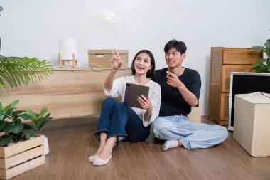 A couple imagines their new home design with digital planning, highlighting creativity and excitement as they decide on decor and layout. clipart