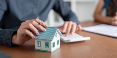 Bir emlakçı, müşterilerine sağlam mali kararlar almada rehberlik etmek için gayrimenkul yatırım fırsatlarını ayrıntılı hesaplamalar yoluyla değerlendirir..