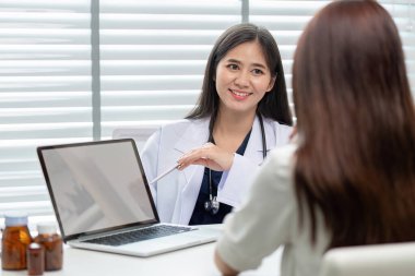 Doktor, tedavi planlarını açıklamak, hasta anlayışını geliştirmek ve bakımda yer almak için dizüstü bilgisayar gibi dijital araçlar kullanıyor..