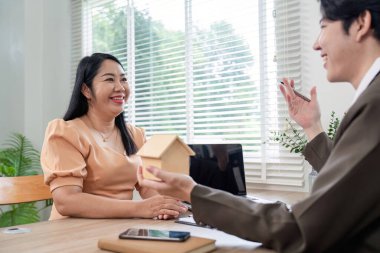 Bir mortgage danışmanı, ev sahipliği çözümleri ve mali planlama üzerine odaklanarak, bir müşteriyle konut planlarını tartışır.