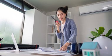 Proaktif bir kadın mühendis, detaylı bir ofis ortamında, etkili iletişim ve planlama içeren projeler yürütüyor..
