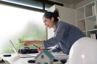 Yenilikçi bir mühendis radyo aracılığıyla dinamik bir ofis içinde, tasarım ve proje yürütmesindeki liderliği yansıtan öngörüler ile iletişim kurar..