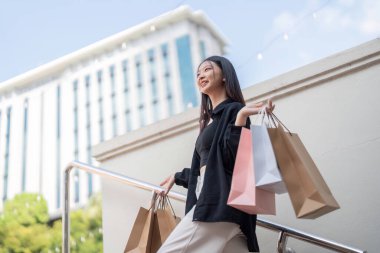 Kendine güvenen bir müşteri, şehir hayatı ile çevrili bir şehir ortamında neşe saçarak Kara Cuma alışverişini yapar..