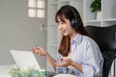 Çevrimiçi bir konferans sırasında aktif olarak dinleyen ve etkileşime geçen genç bir kadın teknoloji ve eğitimi birleştirmektedir..