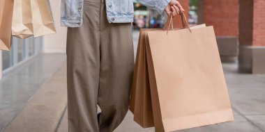 A close up view of a shopper holding eco friendly shopping bags on Black Friday, with a focus on the concept of eco conscious consumer culture. clipart