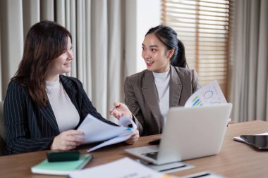 Ortak bir iş stratejisi toplantısında rapor analizi üzerinde duruluyor, takım çalışması ve etkili iletişim kavramı vurgulanıyor.