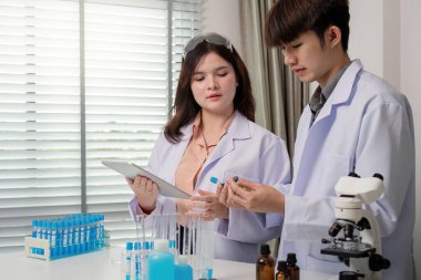 Bir grup bilim adamı laboratuvar örneklerini analiz ediyor, mevcut araştırma sorunlarına yenilikçi çözümler bulmak için beyin fırtınası yapıyorlar..