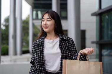 Tatmin olmuş bir müşteri, alışverişini dışarı taşırken Kara Cuma alışveriş deneyiminden zevk alır..