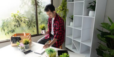 Yenilikçi bir bitki meraklısı, teknoloji ile bahçeciliği birleştirerek, etkin bir fabrika yönetimi için bir tablet kullanır..