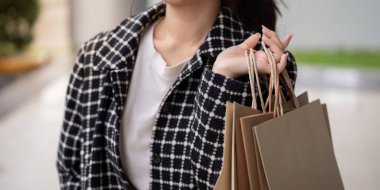 Sayısız alışveriş torbası taşıyan şık bir müşteri başarılı bir Kara Cuma vurgununun heyecanını ve cömertliğini gözler önüne seriyor..