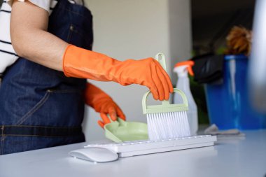 Çalışkan bir temizlikçi ofis hijyenini korumak, temizlik ve düzene bağlılığı vurgulamak için bir faraş seti kullanır.