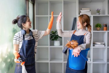 İki hizmetçi iş birliği yaparken beşlik çakıyor ve etkin ev bakımında takım çalışması kavramını somutlaştırıyor..